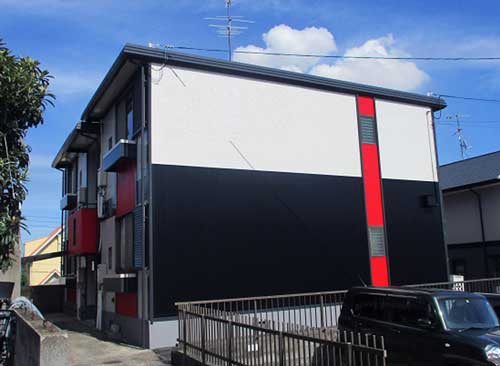 モノトーンに赤のワンポイントが入った住宅外壁