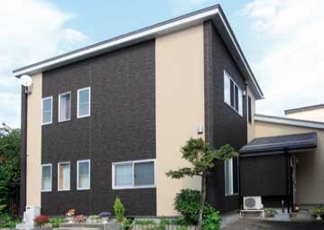 白とグレーで縦に塗り分けられた住宅外壁