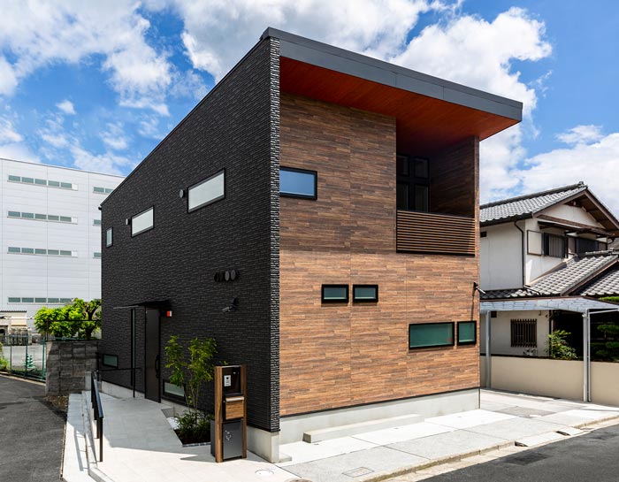 木目柄とブラックのツートン外壁の家