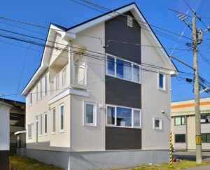 クリーム色とダークグレーのツートン外壁