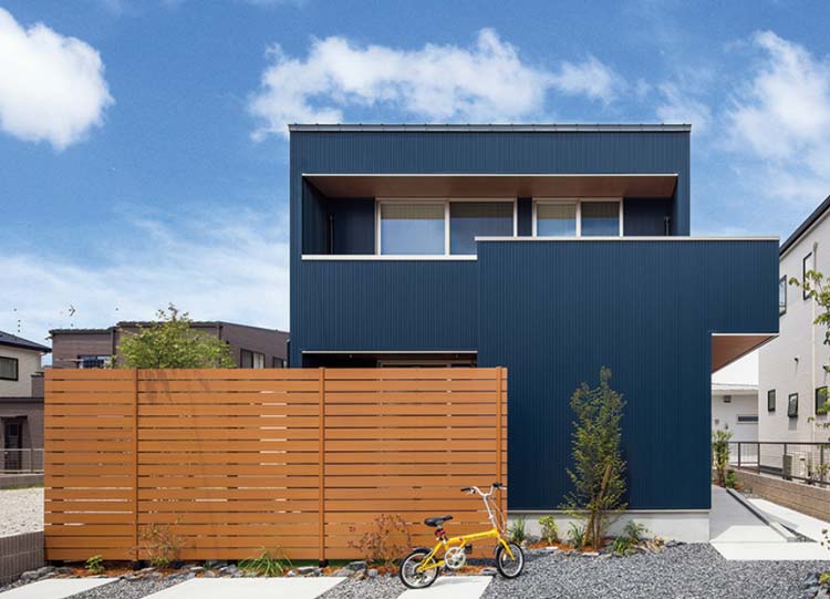 ダークブルーの外壁と陸屋根のモダンな住宅